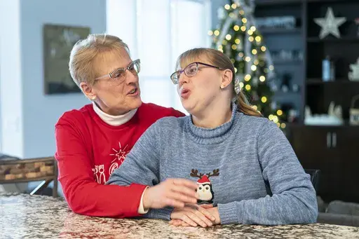 Kathleen Krueger and her daughter, Megan, 28, sit together at their home in Racine, Wis., Friday, Dec. 20, 2024. (AP Photo/Andy Manis)
