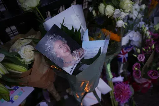 Messages, flowers and candles are seen at the gates of Buckingham Palace in London, Friday, Sept. 9, 2022. (AP Photo/Kirsty Wigglesworth)