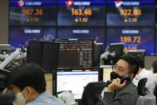 A currency trader watches monitors at the foreign exchange dealing room of the KEB Hana Bank headquarters in Seoul, South Korea, Thursday, May 12, 2022. Shares fell in Asia on Thursday after the release of worse U.S. inflation data than expected sparked heavy selling of technology stocks on Wall Street. (AP Photo/Ahn Young-joon)