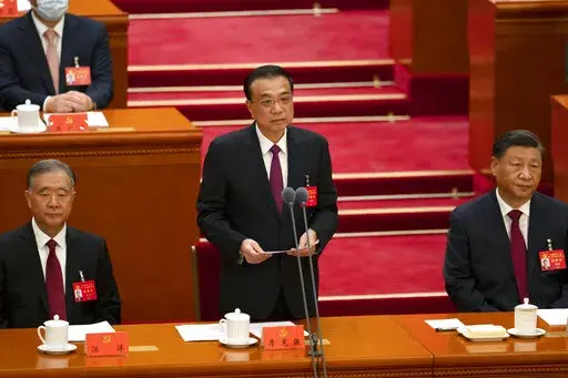 Chinese Premier Li Keqiang is flanked by Politburo Standing Committee member Wang Yang, left, and President Xi Jinping as he speaks during the opening ceremony of the 20th National Congress of China's ruling Communist Party at the Great Hall of the People in Beijing, China, Sunday, Oct. 16, 2022. While Xi is primed to receive a third five-year term as head of China's ruling Communist Party at this week's congress, new members of the party's leading bodies are expected to be appointed at the meet