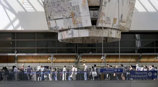 Travelers stand in line at the Tom Bradley International Terminal at LAX on Wednesday, Aug. 30, 2023, in Los Angeles. With Labor Day weekend just days away, airports and roadways are expected to be busy as tens of thousands of Southern Californians travel out of town. (Dean Musgrove/The Orange County Register via AP)