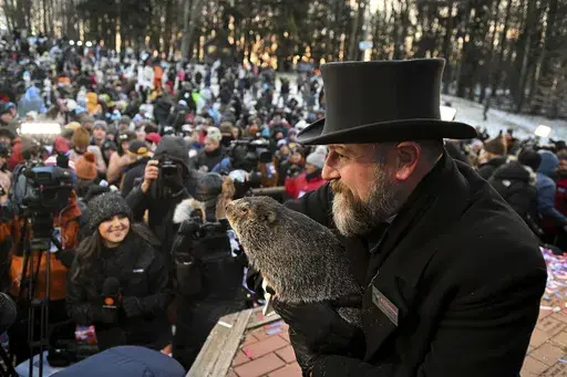 Groundhog Club handler A.J. Dereume holds Punxsutawney Phil, the weather prognosticating groundhog, during the 137th celebration of Groundhog Day on Gobbler's Knob in Punxsutawney, Pa., Feb. 2, 2023. The arrival of annual Groundhog Day celebrations Friday, Feb. 2, 2024, will draw thousands of people to see celebrity woodchuck Phil at Gobbler's Knob in Punxsutawney, Pa. — an event that exploded in popularity after the 1993 Bill Murray movie. (AP Photo/Barry Reeger, File)