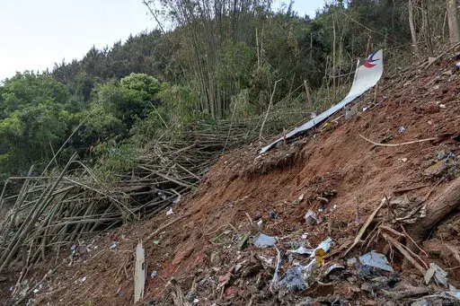 In this photo taken by mobile phone released by Xinhua News Agency, a piece of wreckage of the China Eastern's flight MU5735 are seen after it crashed on the mountain in Tengxian County, south China's Guangxi Zhuang Autonomous Region on Monday, March 21, 2022. A China Eastern Boeing 737-800 with 132 people on board crashed in a remote mountainous area of southern China on Monday, officials said, setting off a forest fire visible from space in the country's worst air disaster in nearly a decade. 