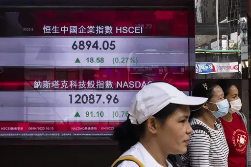Pedestrians walk past the Dah Sing Bank's electronic screen in Hong Kong, Friday, April 7, 2023. The figures displayed on the screen are from Thursday. Asian stock markets followed Wall Street higher on Friday ahead of a U.S. job market update that traders hope might encourage the Federal Reserve to ease off plans for more interest rate hikes. (AP Photo/Louise Delmotte)