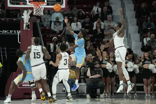 Southern University guard Brandon Davis, second from right, makes a banked shot to score in the final seconds against Mississippi State during the second half of an NCAA college basketball game, Sunday, Dec. 3, 2023, in Starkville, Miss. (AP Photo/Rogelio V. Solis)