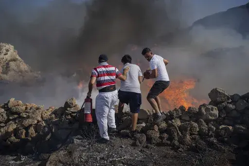 Local residents try to extinguish a fire, near the seaside resort of Lindos, on the Aegean Sea island of Rhodes, southeastern Greece, on July 24, 2023. Greece’s resort island of Rhodes is nursing its wounds after 11 days of devastating wildfires. (AP Photo/Petros Giannakouris, File)