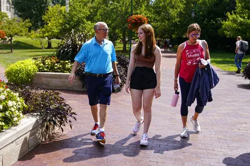 Emily Korenman, freshman, 18, center, from Dallas, walks with her parents Wendy and Phillip through campus at Indiana University in Bloomington, Ind., Tuesday, Aug. 16, 2022. Korenman, who decided to study business at Indiana University, said she was frustrated to learn her new state passed new abortion restrictions that take effect Sept. 15 and allow limited exceptions. The 18-year-old said it didn't change her mind about attending a school she really likes, but she isn’t sure what she would 