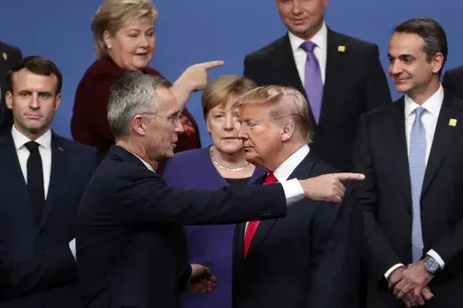 NATO Secretary-General Jens Stoltenberg, front center left, speaks with U.S. President Donald Trump, front center right, after a group photo at a NATO leaders meeting at The Grove hotel and resort in Watford, Hertfordshire, England, Dec. 4, 2019. As Trump becomes the first former president to face federal charges that could put him in jail, many Europeans are watching the case closely. But hardly a single world leader has said a word recently about the man leading the race for the Republican par