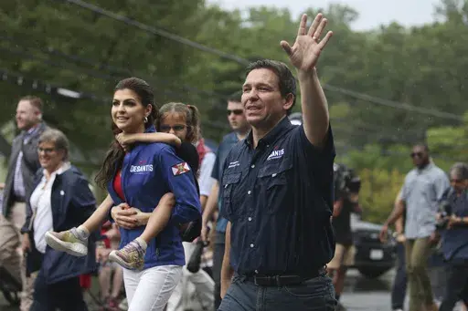 Republican presidential candidate and Florida Gov. Ron DeSantis and his wife Casey, walk in the July 4th parade, Tuesday, July 4, 2023, in Merrimack, N.H. (AP Photo/Reba Saldanha)