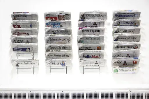 Swiss daily newspapers displayed in the Media Center of the Federal Parliament in Bern, Switzerland, Wednesday, Jan. 5, 2022. On Sunday, Feb. 13, 2022, voters in Switzerland consider on a government's public aid plan to support broadcast and print media. (Peter Klaunzer/Keystone via AP)