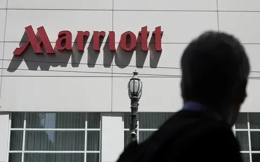 A person walks past the San Francisco Marriott Union Square hotel on July 11, 2019, in San Francisco. Multinational companies including Amazon, Marriott and Hilton pledged Monday June 19, 2023 to hire more than 13,000 refugees, including Ukrainian women who have fled the war with Russia, over the next three years in Europe. (AP Photo/Jeff Chiu, File)