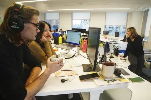 John D'Amico, deputy executive editor for The News Movement (TNM), a social media news operation re-imagined for Gen-Z consumers, left, reviews video with reporter Kimberly Avalos, Wednesday, March 1, 2023, in New York. TNM uses a staff of reporters with an average age of 25 to make tailored news content for sites like TikTok, Instagram, YouTube and Twitter. (AP Photo/Bebeto Matthews)