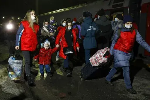 People from the Donetsk and Luhansk regions, the territory controlled by a pro-Russia separatist governments in eastern Ukraine, walk from a train to be taken to temporary residences in the Volgograd region, at the railway station in Volzhsky, Volgograd region, Russia, on Sunday, Feb. 20, 2022. Ukrainian President Volodymyr Zelenskyy, facing a sharp spike in violence in and around territory held by Russia-backed rebels and increasingly dire warnings that Russia plans to invade, has called for Ru