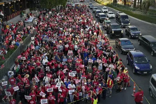 Members of the Culinary Workers Union rally along the Las Vegas Strip, Thursday, Aug. 10, 2023, in Las Vegas. After a marathon week of negotiations, the Las Vegas hotel workers union says it has reached a tentative deal with Wynn Resorts. It was the last contract the Culinary Workers Union needed to avoid a strike Friday, Nov. 10, 2023, and came after the union's tentative deals with Caesars Entertainment and MGM Resorts. (AP Photo/John Locher, File)