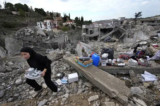 A woman collects the remains of her destroyed house after she returned to Chehabiyeh village, southern Lebanon, Thursday, Nov. 28, 2024 following a ceasefire between Israel and Hezbollah that went into effect on Wednesday.(AP Photo/Hussein Malla)
