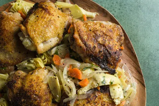 This image released by Milk Street shows a recipe for chicken with artichokes and white wine. (Milk Street via AP)