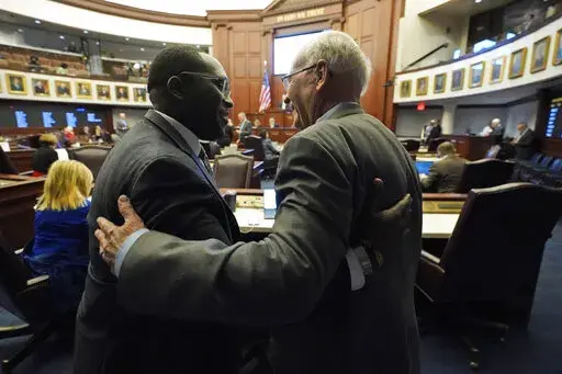 Florida Sen. Dennis Baxley, right, the sponsor of a bill, dubbed by opponents as the "Don't Say Gay" bill, hugs an opponent of the bill, Sen. Shevrin Jones, after the bill passed during a legislative session at the Florida State Capitol, Tuesday, March 8, 2022, in Tallahassee, Fla. (AP Photo/Wilfredo Lee)