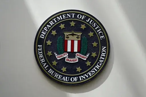 An FBI seal is seen on a wall on Aug. 10, 2022, in Omaha, Neb. The FBI says scammers stole more than $3.4 billion from older Americans last year. An FBI report released Tuesday shows a rise in losses through increasingly sophisticated tactics to trick the vulnerable into giving up their life savings. (AP Photo/Charlie Neibergall, File)