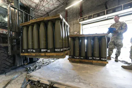 U.S. Air Force Staff Sgt. Cody Brown, right, with the 436th Aerial Port Squadron, checks pallets of 155 mm shells ultimately bound for Ukraine, April 29, 2022, at Dover Air Force Base, Del. On Sept. 15, 2023, The Associated Press reported on a false claim online that the U.S. accidentally sent Ukraine $6 billion in military aid. The claim misrepresents remarks by a Pentagon spokesperson. (AP Photo/Alex Brandon, File)