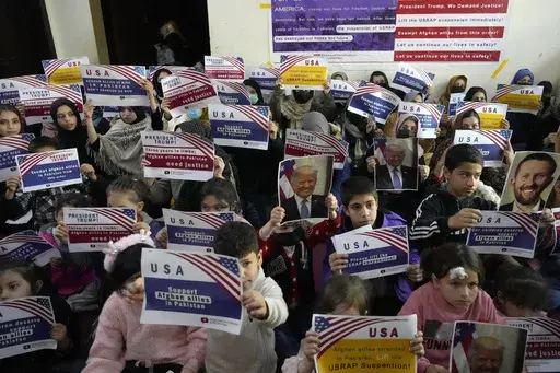 Afghan refugees hold placards during their meeting to discuss situation after President Donald Trump paused the U.S. refugee programs, in Islamabad, Pakistan, Friday, Jan. 24, 2025. (AP Photo/Anjum Naveed)