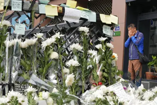 A man weeps as he pays tribute to victims of a deadly accident following Saturday night's Halloween festivities on a street near the scene in Seoul, South Korea, Tuesday, Nov. 1, 2022.  South Korean police investigated on Monday what caused a crowd surge that killed more than 150 people during Halloween festivities in Seoul in the country’s worst disaster in years. (AP Photo/Ahn Young-joon)