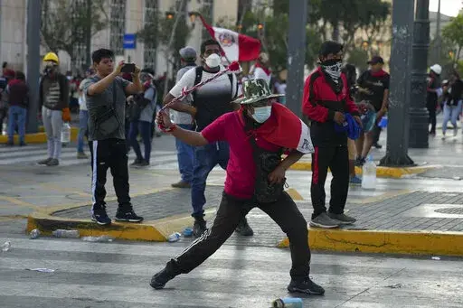 Anti-government protesters clash with police in Lima, Peru, Tuesday, Jan. 24, 2023. Protesters are seeking the resignation of President Dina Boluarte, the release from prison of ousted President Pedro Castillo, immediate elections and justice for demonstrators killed in clashes with police. (AP Photo/Guadalupe Pardo)