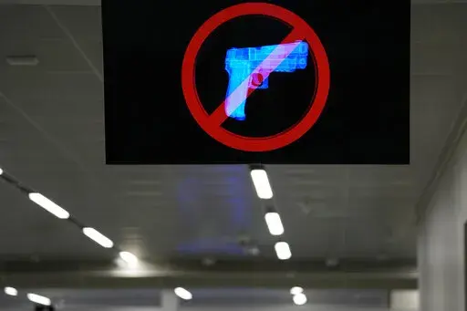 A television displays a "no guns" sign at the Transportation Security Administration security area at the Hartsfield-Jackson Atlanta International Airport on Wednesday, Jan. 25, 2023, in Atlanta. Last year saw a record number of guns intercepted at airport checkpoints across the country. The numbers have been steadily climbing and hit 6,542 last year. The head of the Transportation Safety Administration, David Pekoske, says this is a reflection of what is going on in society and in “society th
