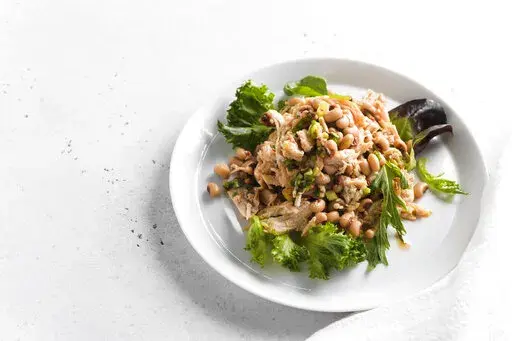 This image released by Milk Street shows a recipe for Chicken and Bean Salad with Pepper Jelly Vinaigrette. (Milk Street via AP)