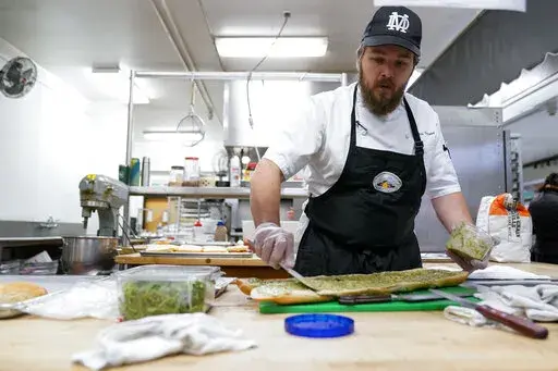 Chef Josh Gjersand prepares a sandwich for Mount Diablo High School students to try during a taste test in Concord, Calif., Friday, Jan. 13, 2023. The school district in suburban San Francisco has been part of a national "farm-to-school" movement for years, where schools try to buy as much locally as possible. But the mission has been kicked into higher gear with a California program that provides free meals to all public school students in the state, along with unprecedented new funding. (AP Ph