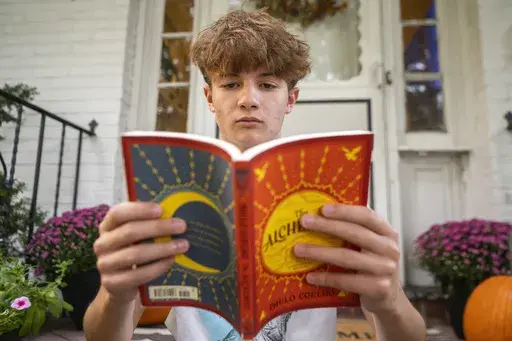Chris Stanislawski, 14, poses for a portrait outside of his home in Garden City, N.Y., on Friday, Sept. 13, 2024. Chris didn't finish any books in his 8th grade English class, in part because their google classroom had detailed summaries of each chapter of every book. (AP Photo/Brittainy Newman)