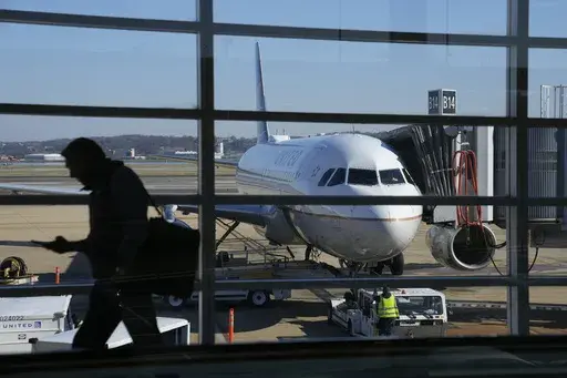 A United Airlines plane sits at a gate at Ronald Reagan Washington National Airport in Arlington, Va., Nov. 23, 2022. United Airlines says that it will start boarding passengers in economy class with window seats first starting next week, a move that will speed up boarding times for flights. (AP Photo/Patrick Semansky, File)