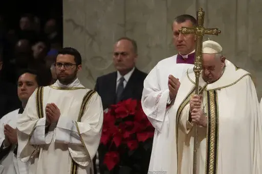 Pope Francis holds his pastoral staff as he presides over Christmas Eve Mass, at St. Peter's Basilica at the Vatican, Saturday Dec. 24, 2022. (AP Photo/Gregorio Borgia)