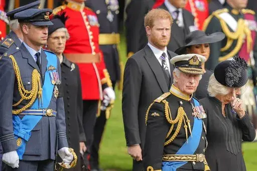 King Charles III, from right, Camilla, the Queen Consort, Meghan, Duchess of Sussex, Prince Harry and Prince William watch as the coffin of Queen Elizabeth II is placed into the hearse following the state funeral service in Westminster Abbey in central London on Sept. 19, 2022. Prince Harry has said he wants to have his father and brother back and that he wants “a family, not an institution” during a TV interview ahead of the publication of his memoir. The interview with Britain's ITV channe