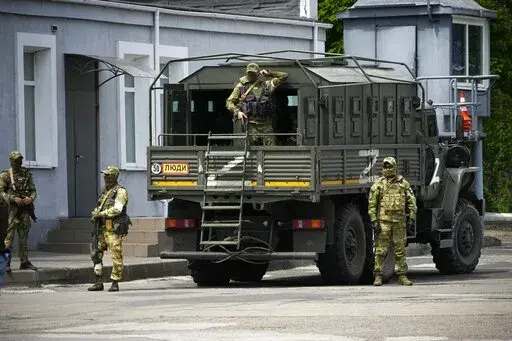 Russian soldiers guard an area as a group of foreign journalists visit in Kherson, Kherson region, south Ukraine, May 20, 2022. The southern city of Kherson was the first to fall to Russia's invasion. But Kherson remains at the heart of the conflict and Ukraine's efforts to save its vital access to the sea. (AP Photo, File)