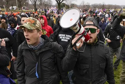 Proud Boys members Zachary Rehl, left, and Ethan Nordean, walk toward the U.S. Capitol in Washington, in support of President Donald Trump, Jan. 6, 2021. Federal prosecutors disclosed Wednesday, March 22, 2023, that a witness expected to testify for the defense at the seditious conspiracy trial of former Proud Boys leader Enrique Tarrio and four associates was secretly acting as a government informant for nearly two years after the Jan. 6 attack on the U.S. Capitol, a defense lawyer said in a co