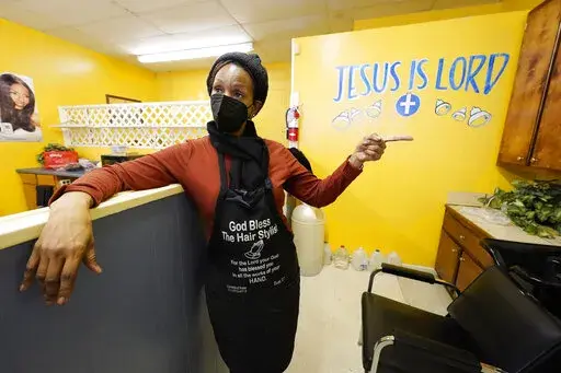 Belinda Smith, owner of Styles of Essence, a hair salon in south Jackson, Miss., speaks of the need to have gallons of water available to use for rinsing clients hair because of the uncertainty of the city's water service, Wednesday, Jan. 26, 2022. The city's ongoing water woes sometimes requires the area water to be shut off without warning. (AP Photo/Rogelio V. Solis)