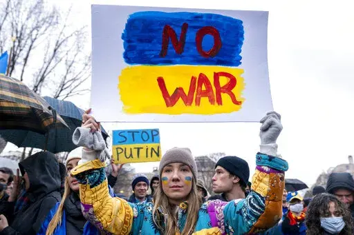 Ukrainian Oleksandra Yashan holds a sign that reads "No War" during a vigil to protest the Russian invasion of Ukraine in Lafayette Park in front of the White House in Washington, Thursday, Feb. 24, 2022. Ukrainians in the United States are praying for friends and family, donating money and supplies, and attending demonstrations. (AP Photo/Andrew Harnik, File)