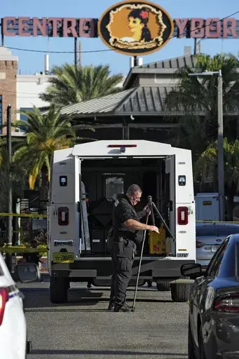 A Tampa police officer opens a tripod in the Ybor City section of Tampa, Fla., after a shooting early Sunday, Oct. 29, 2023. A fight between two groups turned deadly in a shooting during Halloween festivities. (AP Photo/Chris O'Meara)
