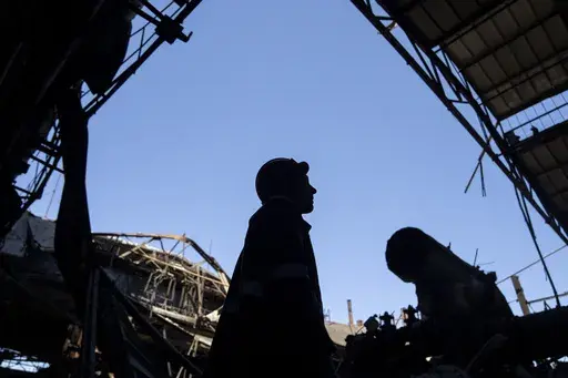 Workers remove debris from the roof of a damaged DTEK thermal power plant after a Russian attack in Ukraine, Thursday, May 2, 2024. Ukrainian energy workers are struggling to repair the damage from intensifying airstrikes aimed at pulverizing Ukraine's energy grid, hobbling the economy and sapping the public's morale. (AP Photo/Francisco Seco)