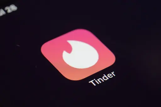 The icon for the dating app Tinder appears on a device, July 28, 2020, in New York. Tinder, Hinge and other dating apps are designed with addictive features that encourage “compulsive” use, a proposed class action lawsuit against parent company Match Group claims. The lawsuit filed Wednesday, Feb. 14, 2024, says Match intentionally designs its dating platforms with game-like features that “lock users into a perpetual pay-to-play loop” prioritizing profit over promises to help users find 