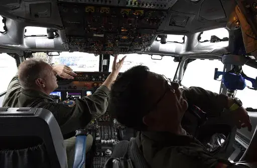 Pilots work in the cockpit of an AWACS plane at Melsbroek military airport in Melsbroek, Belgium, Wednesday, Nov. 27, 2019. As Russia’s military buildup near Ukraine accelerated early this year, military planners at NATO began preparing to dispatch scores of fighter jets and surveillance aircraft into the skies near Russia and Ukraine. It was a warning to Moscow not to make the mistake of targeting any member country. (AP Photo/Virginia Mayo, File)