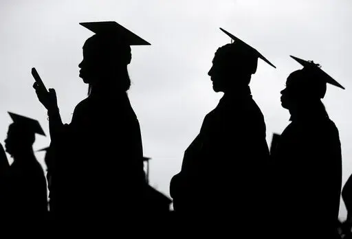 New graduates line up before the start of a community college commencement in East Rutherford, N.J., on May 17, 2018. President Joe Biden is expected to announce Wednesday Aug. 24, 2022 that many Americans can have up to $10,000 in federal student loan debt forgiven. (AP Photo/Seth Wenig, File)