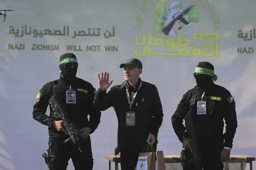 American-Israeli hostage Keith Siegel, 65, center left, waves as he is escorted by Hamas fighters to be handed over to the Red Cross in Gaza City, Saturday Feb.1, 2025.(AP Photo/Mohammed Hajjar, File)