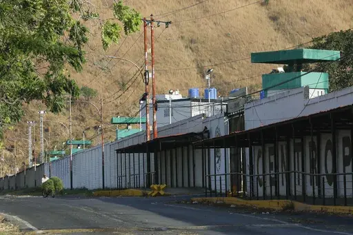 A man rides a bicycle past the Aragua Penitentiary Center in Tocorón, Venezuela, Saturday, March 22, 2025. (AP Photo/Cristian Hernandez)