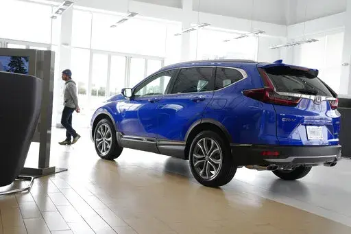 A potential buyer surveys a 2022 CR-V sports-utility vehicle on the showroom floor of a Honda dealership, Thursday, Nov. 3, 2022, in Highlands Ranch, Colo. (AP Photo/David Zalubowski, File)