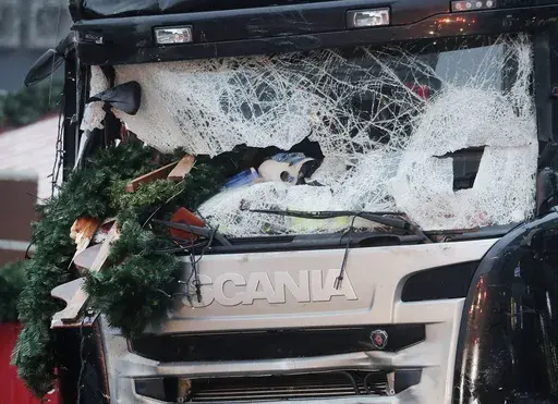 In this Dec. 20, 2016 file photo Christmas decoration sticks in the smashed window of the cabin of a truck which ran into a crowded Christmas market Monday evening killing several people in Berlin, Germany. (AP Photo/Markus Schreiber, file)