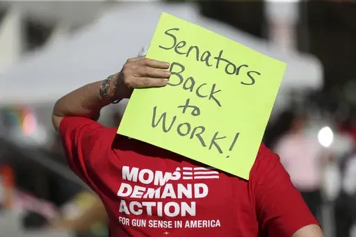 An attendee holds a sign behind their head during a rally calling for an end to the Senate Republican walkout at the Oregon State Capitol in Salem, Ore., May 11, 2023. Republicans and an independent senator in the Oregon Senate stretched a walkout Monday, May 15, to 10 days, triggering a new constitutional provision that prohibits lawmakers with 10 or more unexcused absences from being reelected. The walkout that began May 3 has stalled action on hundreds of bills, including on gun control, gend