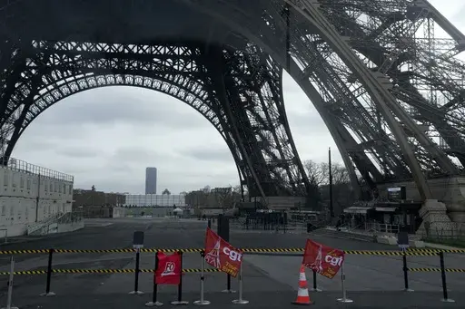 Unions flags are pictured at the Eiffel Tower, Tuesday, Feb. 20, 2024 in Paris. Visitors to the Eiffel Tower were turned away for the second consecutive day because of a strike over poor financial management at one of the world's most-visited sites. (AP Photo/Michel Euler)
