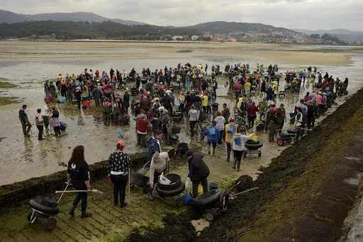 Clam diggers gather in the lower estuary of Lourizan, before starting their work day in Galicia, northern Spain, Thursday, April 20, 2023. They fan out in groups, mostly women, plodding in rain boots across the soggy wet sands of the inlet, making the most of the low tide. These are the clam diggers, or as they call themselves, "the peasant farmers of the sea." Clam collecting in the expansive inlets of Spain's northwestern region of Galicia is a deep-rooted tradition from time eternal and has b