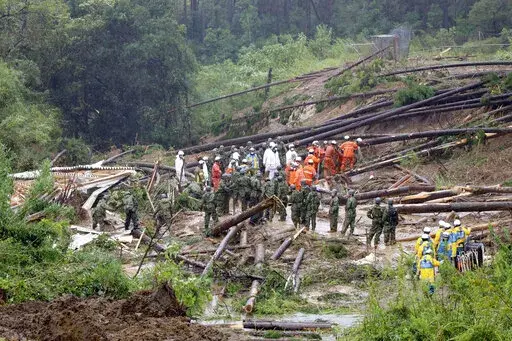 Rescuers conduct a search operation at the site of a landslide in Mimata, Miyazaki Prefecture, southern Japan, Monday Sept. 19, 2022. Powerful Typhoon Nanmadol slammed ashore in southern Japan on Sunday as it pounded the region with strong winds and heavy rain, causing blackouts, paralyzing ground and air transportation and prompting the evacuation of thousands of people. (Kyodo News via AP)